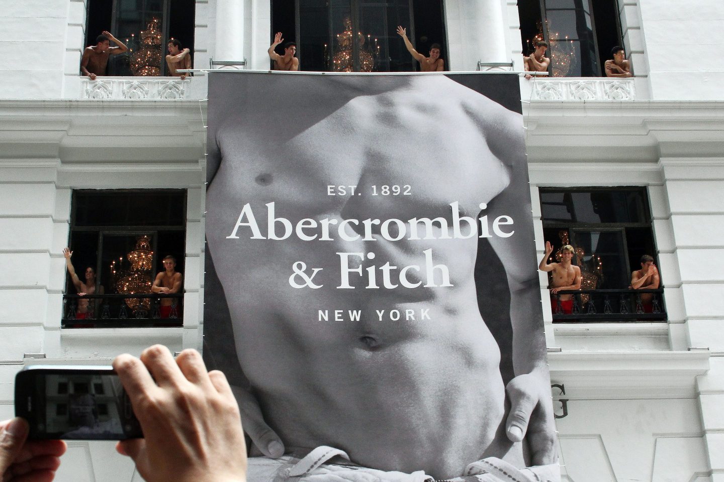 大型 Abercrombie & Fitch 标志，上面有一个男人赤裸的躯干